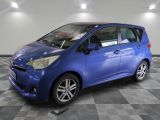 une voiture bleue garée dans un garage au sol en damier