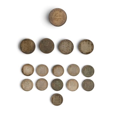 several old coins are arranged in a triangle on a white surface