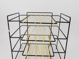 a close up of a black and yellow wire rack with four shelves