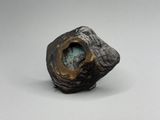 gros plan d'un objet métallique sur une surface blanche