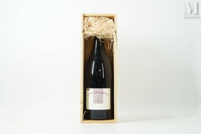 the bottle of wine is in a wooden box on a white surface