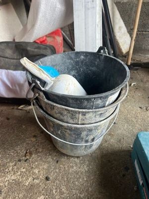 un seau contenant une brosse à dents, posé par terre