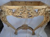 a gold table with a wooden top on a white cloth