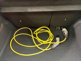 a yellow hose in the trunk of a car