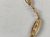 a close up of a gold bracelet on a white surface