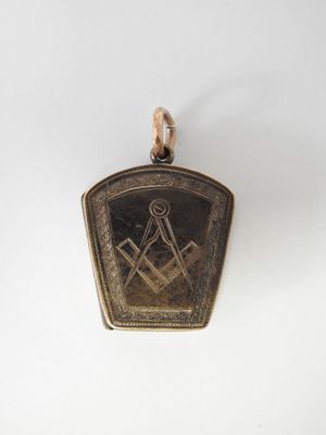 un pendentif plaqué or représentant un paysage de montagne