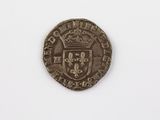 une vieille pièce de monnaie sur laquelle figure une couronne, posée sur une surface blanche