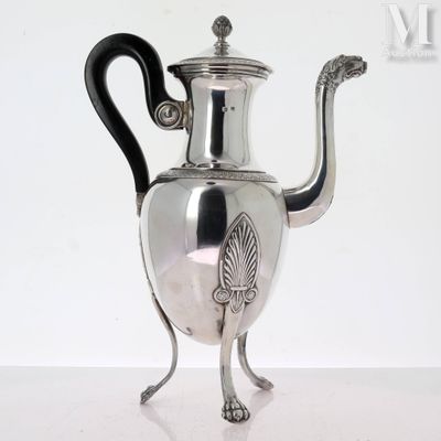 une théière en argent avec une anse noire posée sur une table