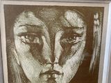 painting of a woman ' s face in a frame on a wall
