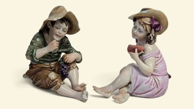 deux figurines représentant un garçon et une fille assis l'un à côté de l'autre