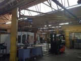 a large warehouse with a fork lift in the middle of it