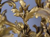 close up of a gold colored chandelier with flowers and leaves