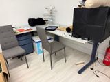 a desk with two chairs and a television in the corner