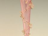 un vase en verre rose avec un socle doré posé sur une table