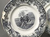 two blue and white plates with a picture of a man riding a horse