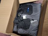 a cardboard box filled with clothes on the floor