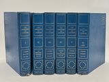 four blue books are stacked on top of each other on a white surface