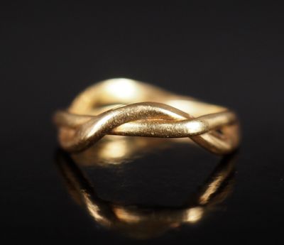 gros plan d'une bague en or sur une surface noire