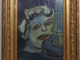 portrait of a woman in a gold frame on a white wall