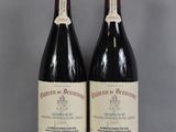 deux bouteilles de vin rouge posées sur une table en verre
