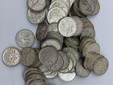 pile of silver coins on a white surface