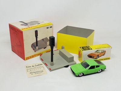 une petite voiture verte posée à côté d'une boîte contenant d'autres petites voitures