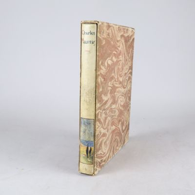 un vieux livre posé sur une table blanche à côté d'un mur blanc
