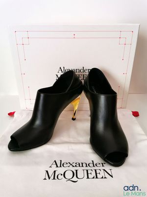 Les chaussures Alexander McQueen sont exposées devant une boîte