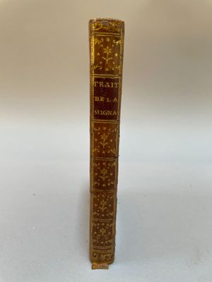 un vieux livre posé sur une table blanche à côté d'un mur blanc