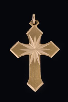 pendentif en forme de croix en or avec un motif en forme d'étoile rayonnante sur fond noir