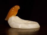an orange bird sitting on top of a white object