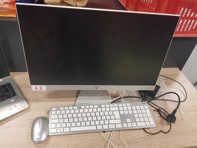 a computer monitor and keyboard on a desk next to a laptop