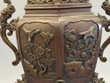 a bronze urn with a bird on top of it