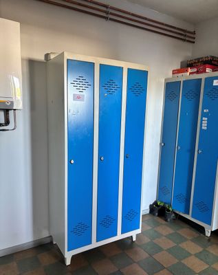deux casiers bleus dans une pièce au sol à carreaux