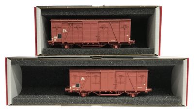 deux wagons rouges dans une boîte sur fond blanc