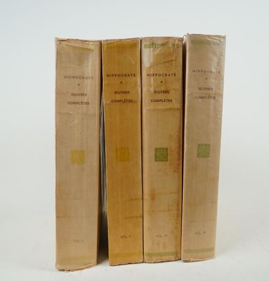 trois vieux livres posés l'un sur l'autre sur une surface blanche