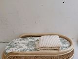 a wicker bed with a blanket on top of it