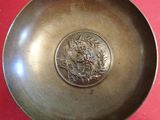 a metal bowl with a picture of a woman on it