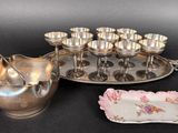 a silver plate with a pitcher and cups on it