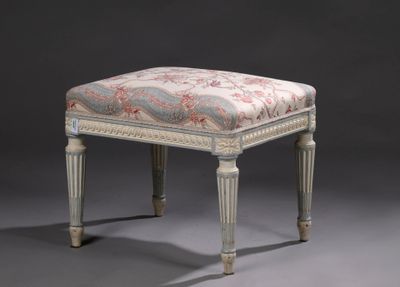 un repose-pieds rembourré dont l'assise est recouverte d'un tissu à motifs floraux