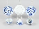 several pieces of blue and white porcelain are arranged on a table