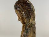 statue of a woman sitting on a rock with her head down