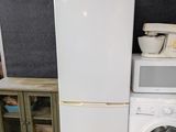 a white refrigerator next to a washing machine in a room