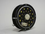 a close up of a fishing reel on a white surface