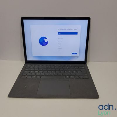 an open laptop computer sitting on top of a white table