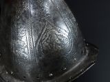 a close up of a metal helmet on a black background