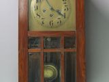 a wooden clock hanging on the wall in the room