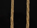 an image of a gold necklace on a black background
