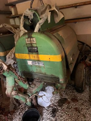 un tracteur qui est garé dans un garage, équipé d'un godet