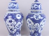 pair of blue and white vases with lids on a white background